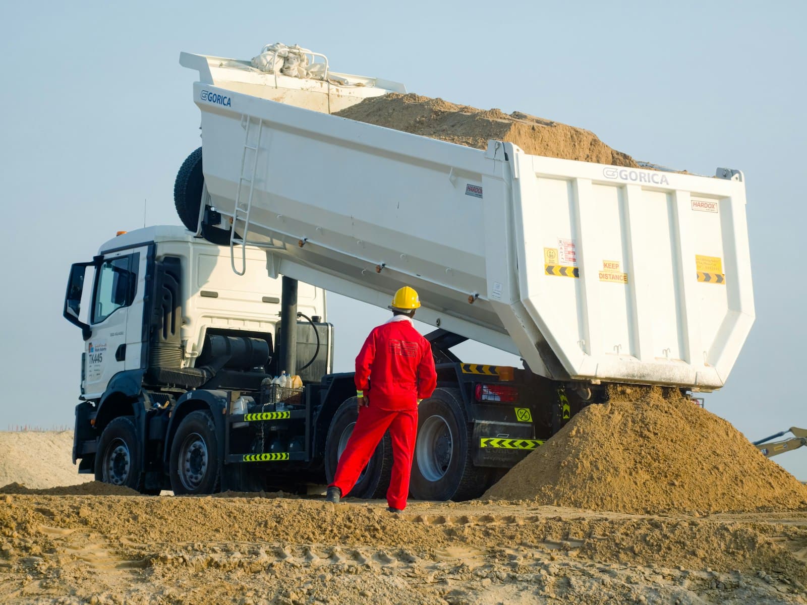 Un camion-benne décharge du sable sur un chantier
