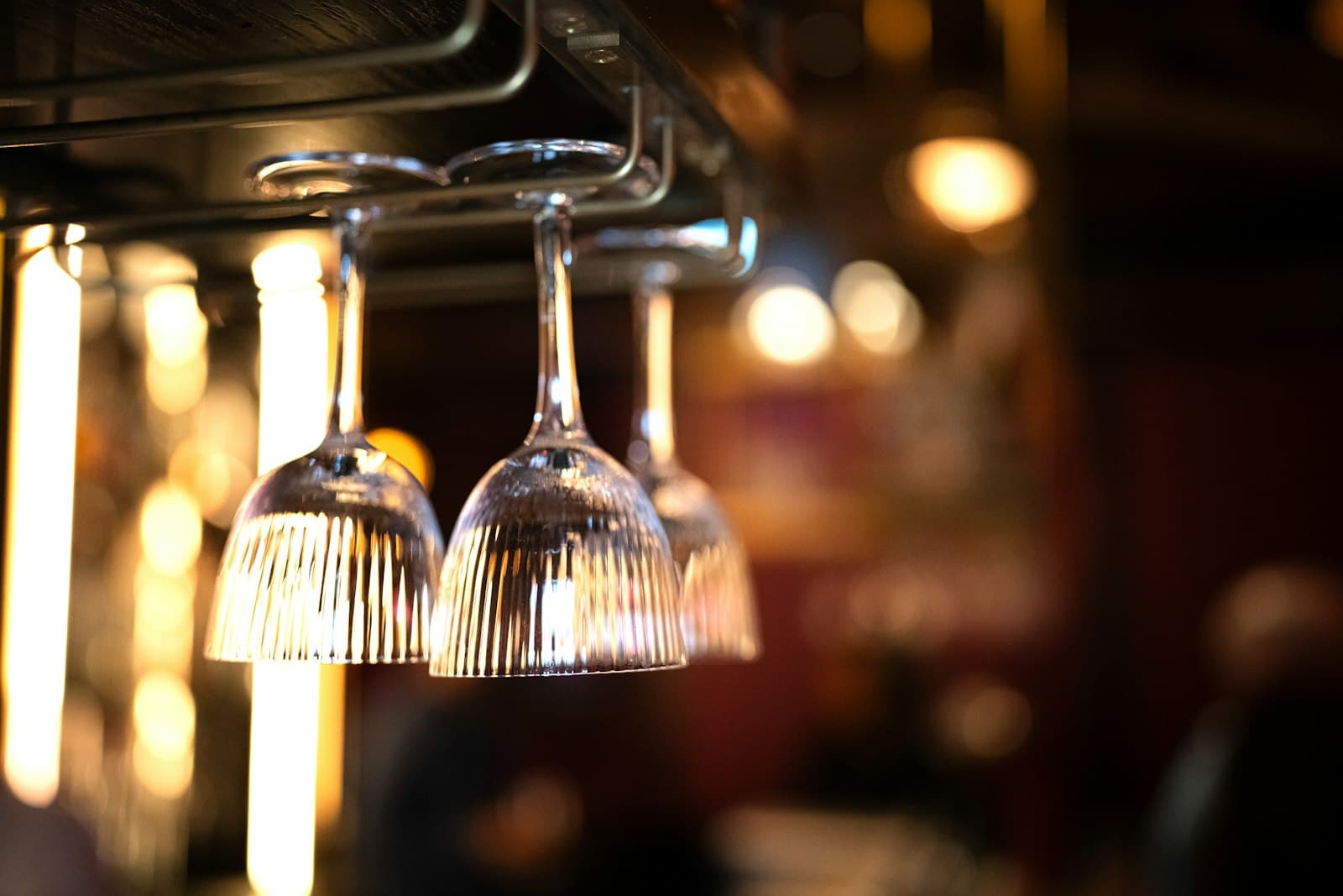 Des verres à vin suspendus à un support de bar